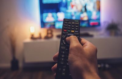 photo of person holding remote control watching television